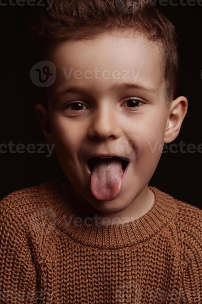 Portrait of joy happy white Caucasian preschooler child boy kid with tongue hanging out photo