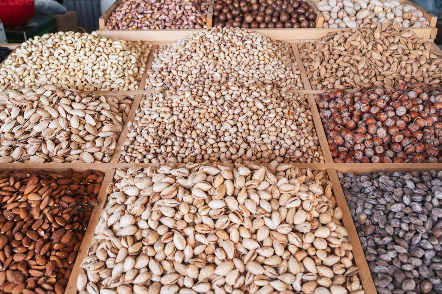 assortment of different nuts on counter at oriental uzbek bazaar. Almonds, pistachios, hazelnuts, macadamia, pecans and cashews photo