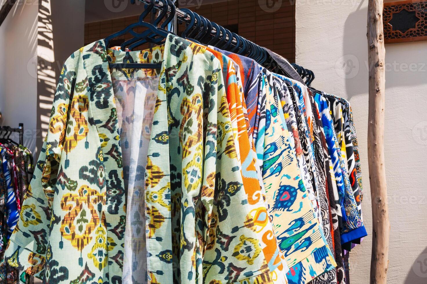 Uzbek dresses and female clothes made cotton with a colorful pattern at oriental bazaar in Uzbekistan photo