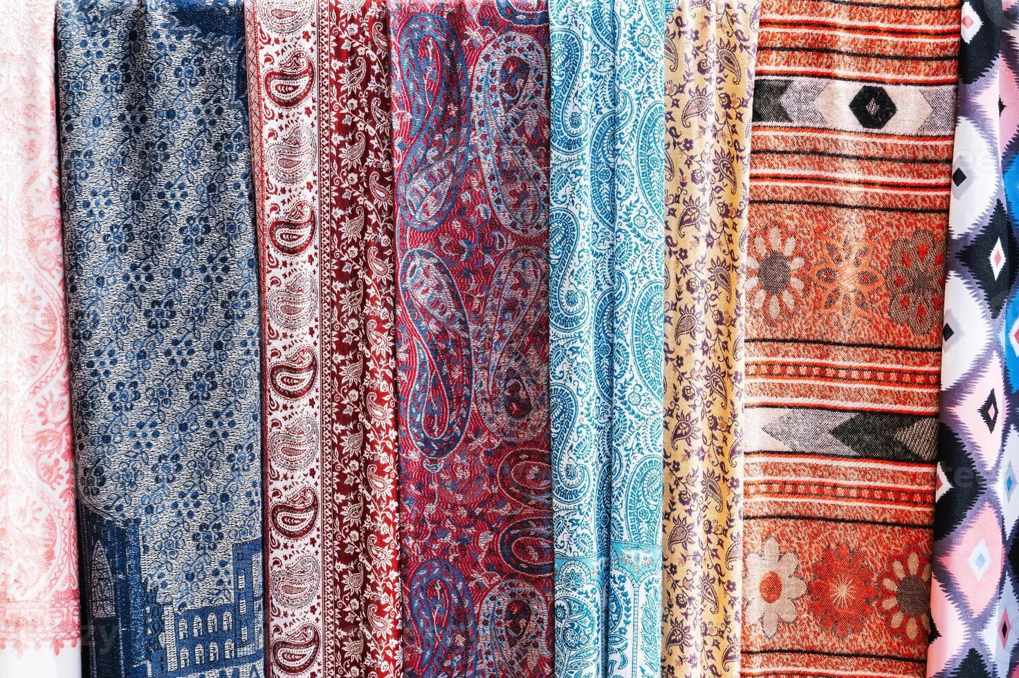 Traditional silk Indian scarves with a bright colorful pattern at an Asian bazaar in India close up photo