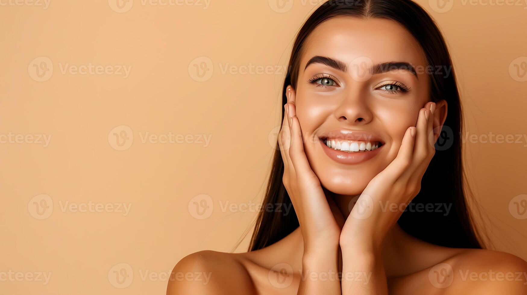 A beautiful woman with a bright smile and flawless skin, looking directly at the camera, with her hands on her cheeks. photo