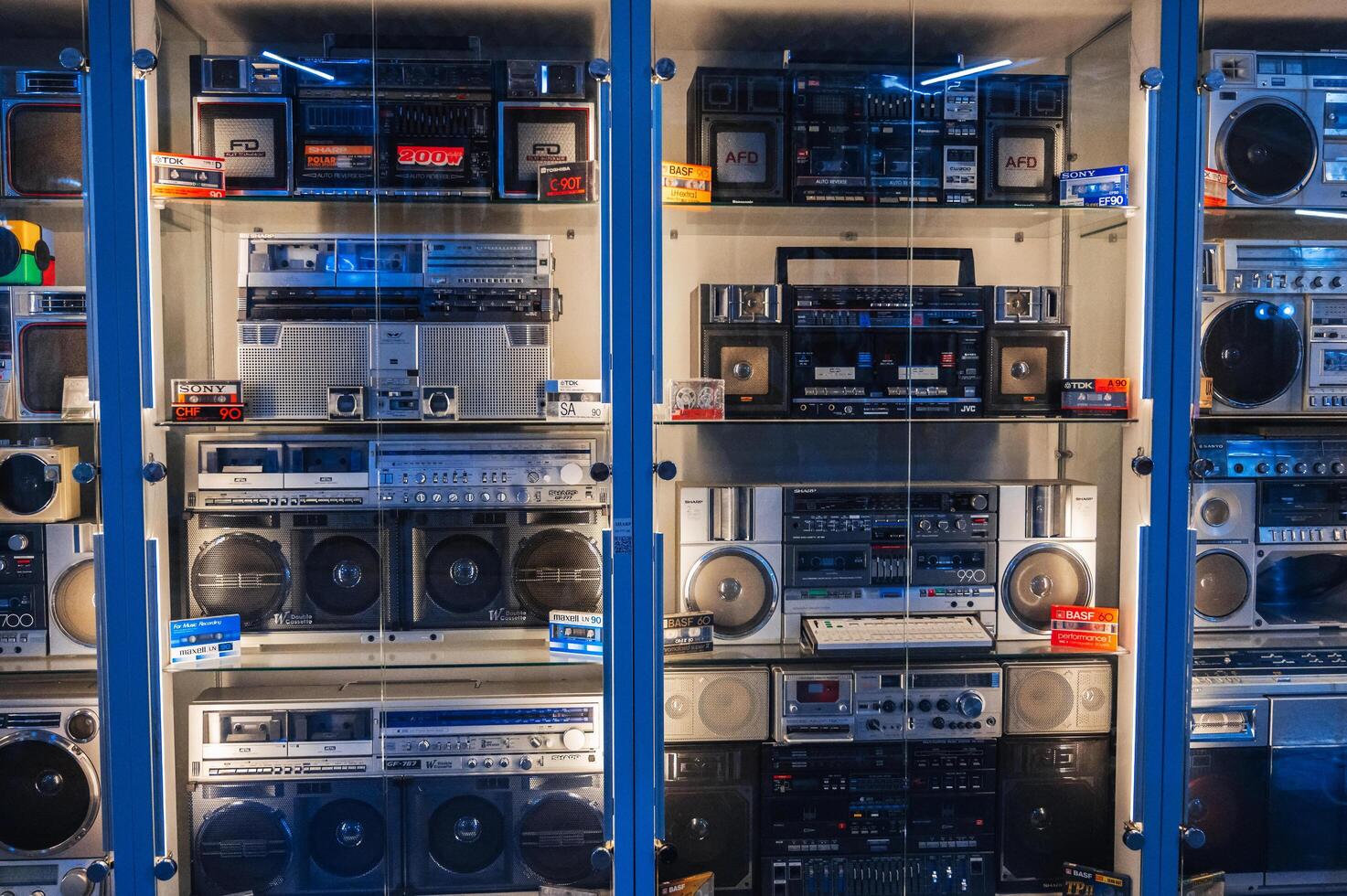 collection of various classic Japanese cassette recorders, portable boomboxes and film tape audio cassettes on store shelf. Tashkent, Uzbekistan - April 16, 2024 photo
