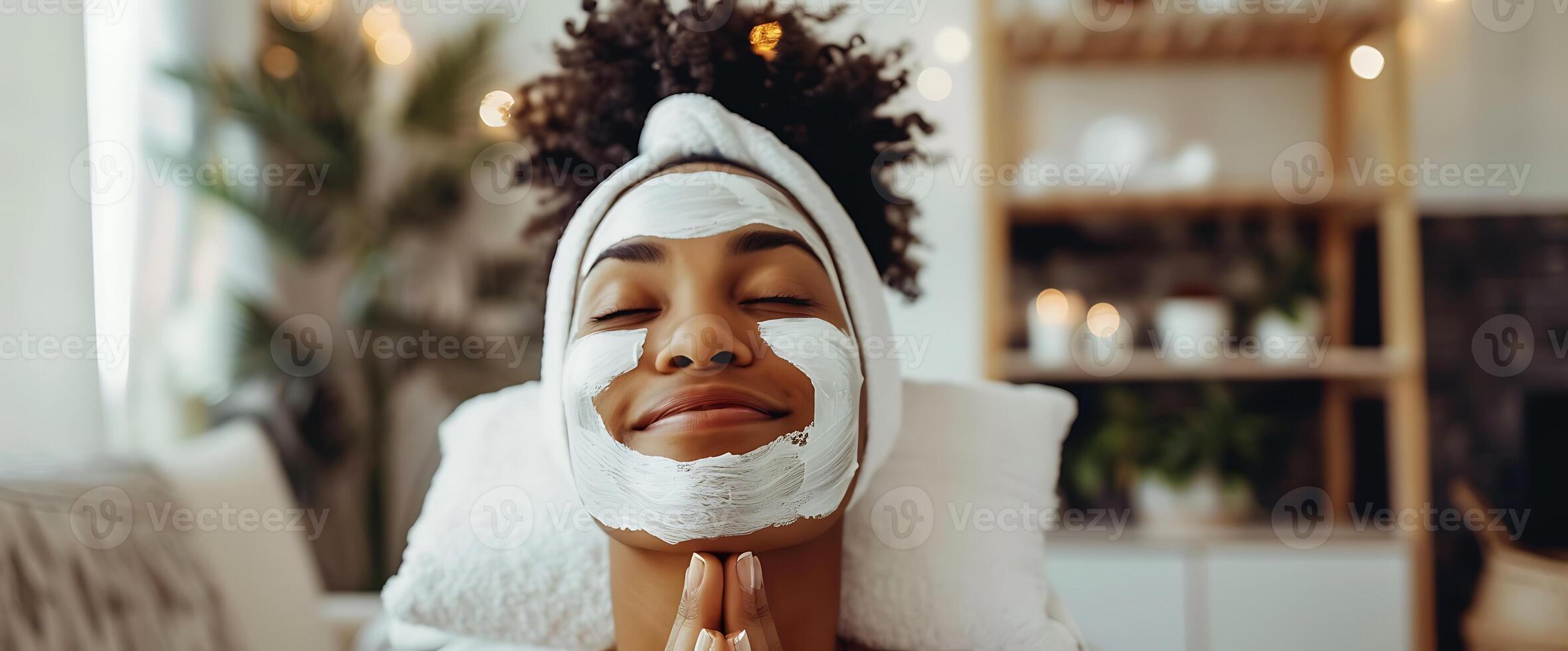 Young woman with a facial mask relaxing on a couch. photo