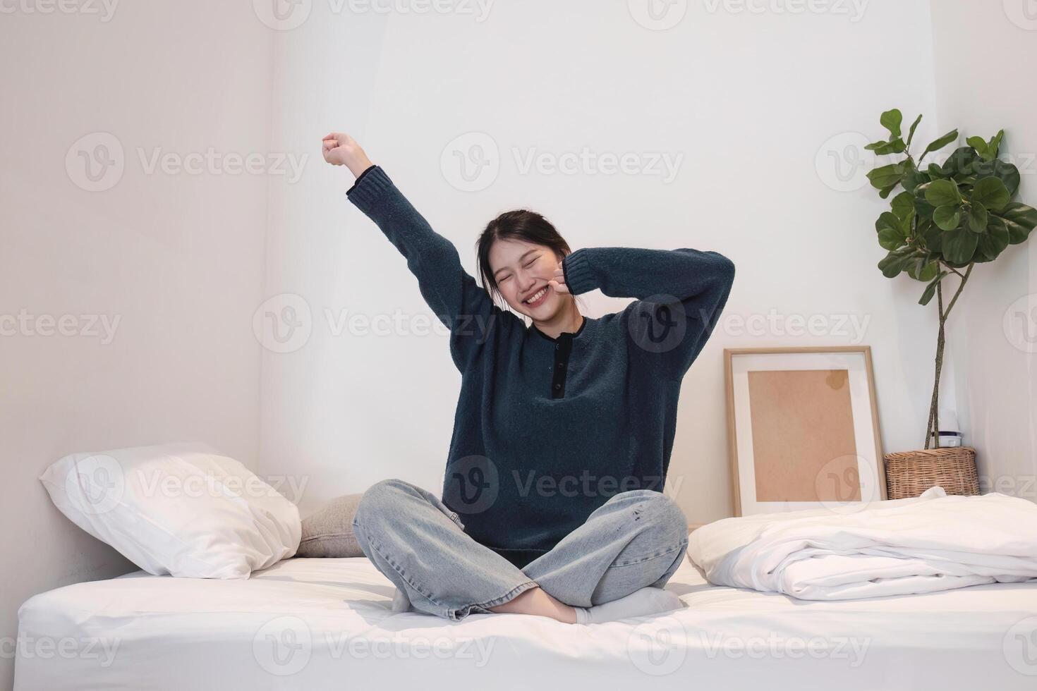 Young Woman Relaxing on Bed in Cozy Modern Bedroom with Minimalist Decor and Natural Light photo