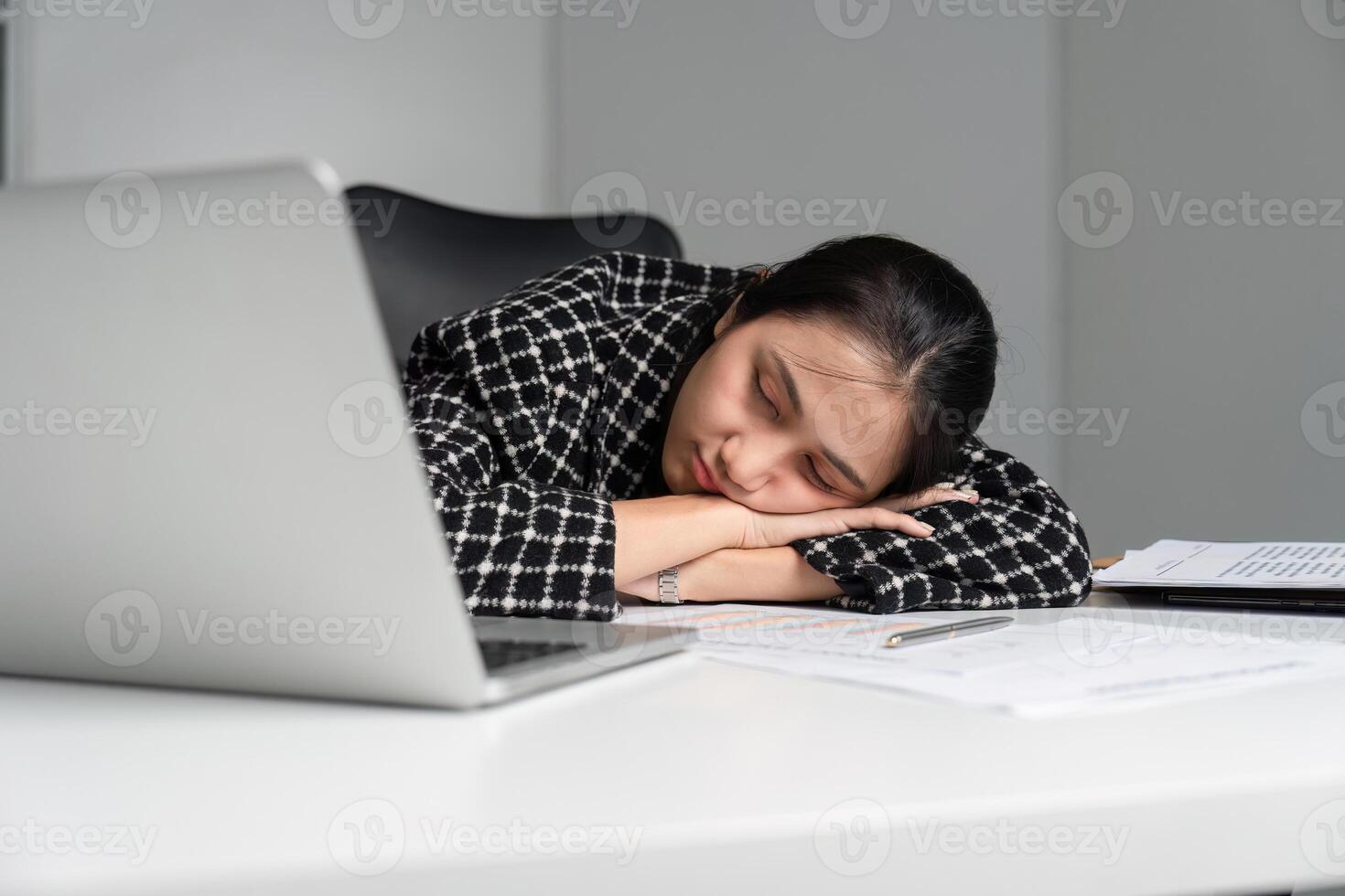 Exhausted Office Worker Sleeping at Desk with Laptop and Documents After a Long Day of Work photo