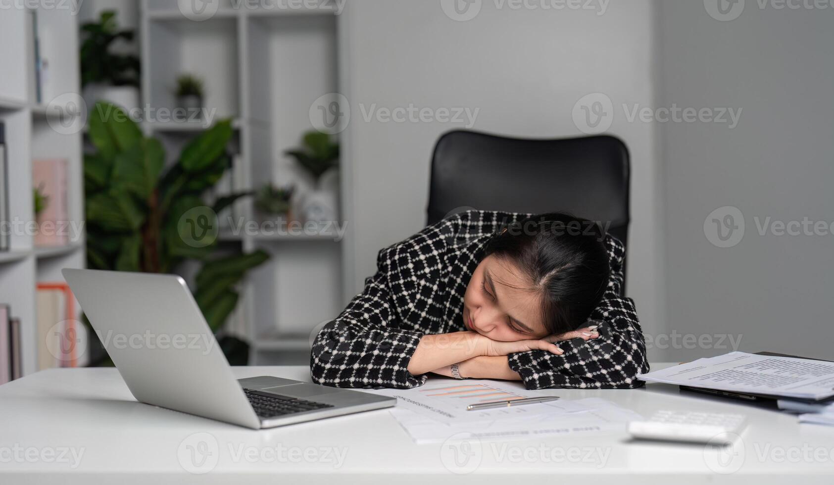 Exhausted Office Worker Sleeping at Desk with Laptop and Documents in Modern Workspace photo