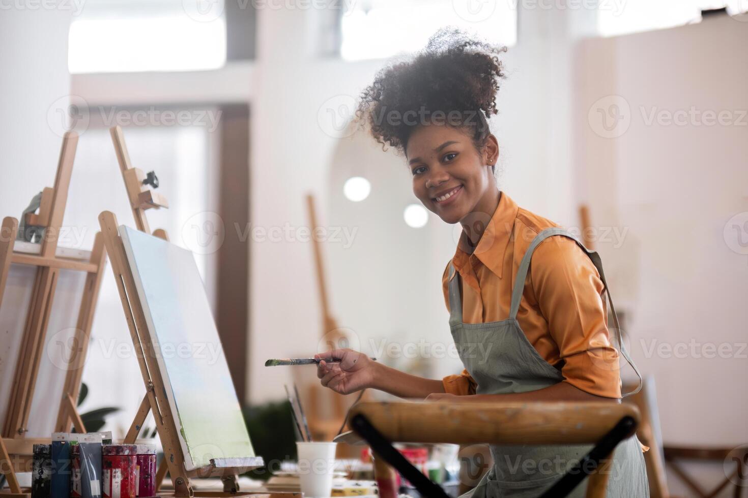 Young Girl Joyfully Drawing in a Bright and Modern Painting Studio with Art Supplies and Easels photo