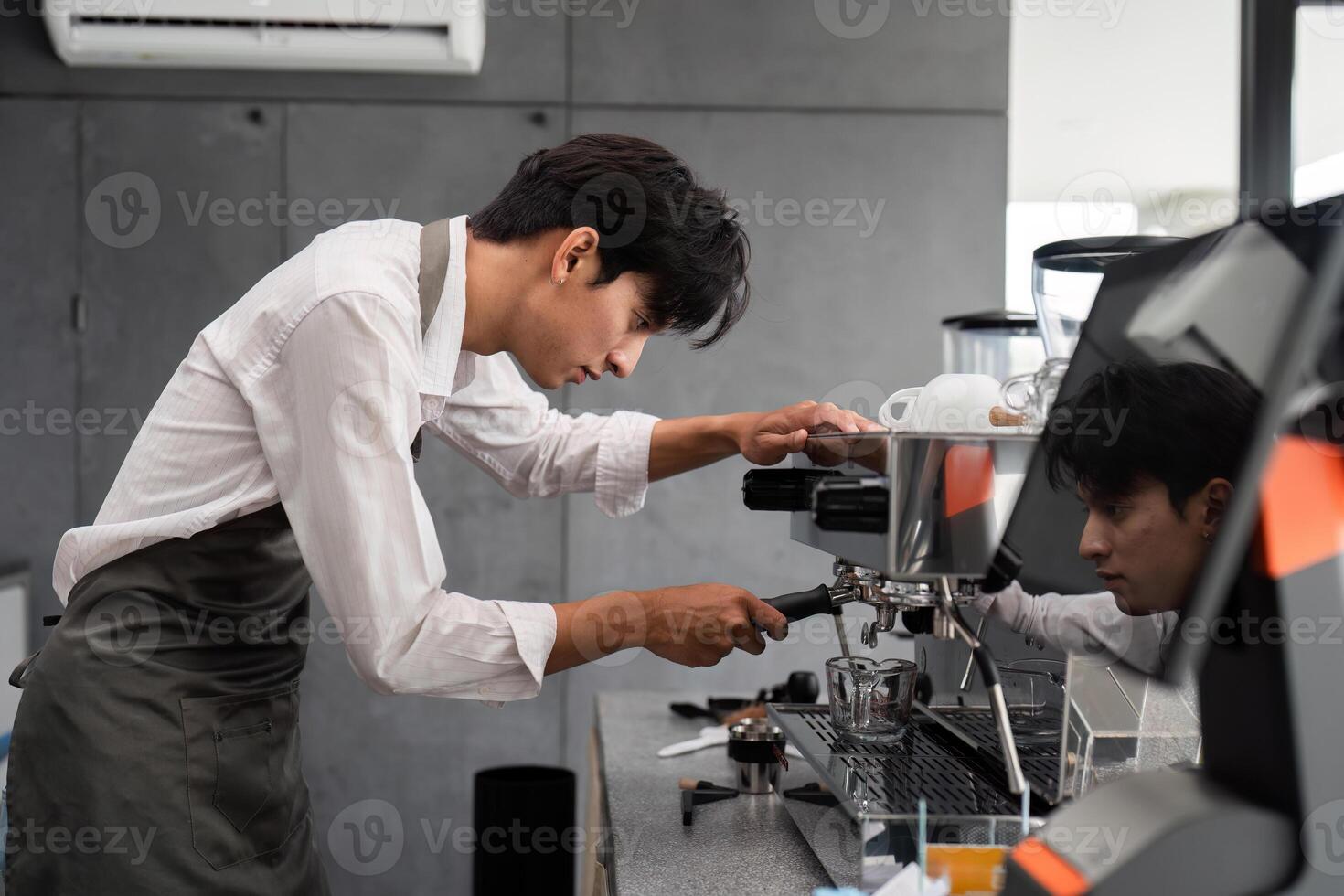 Focused Male Barista Preparing Espresso in Modern Coffee Shop with Professional Equipment photo