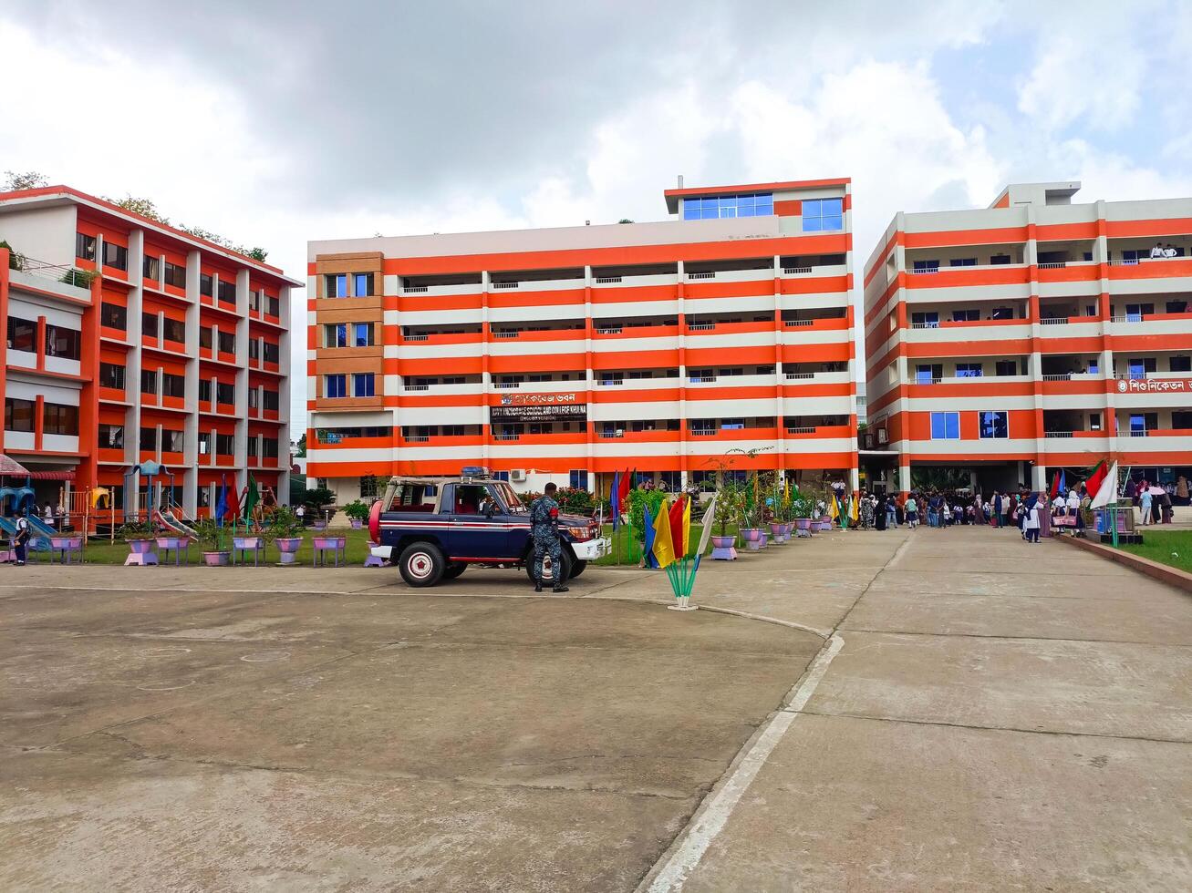 Cross View Of Orange And White School Building With Parking And Bared Walkways photo