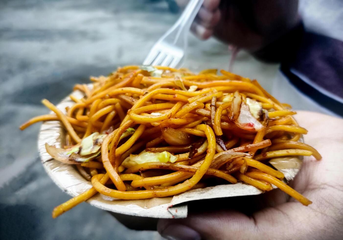 Asian man eating noodle. man hands holding fork and spoon during eating noodle photo