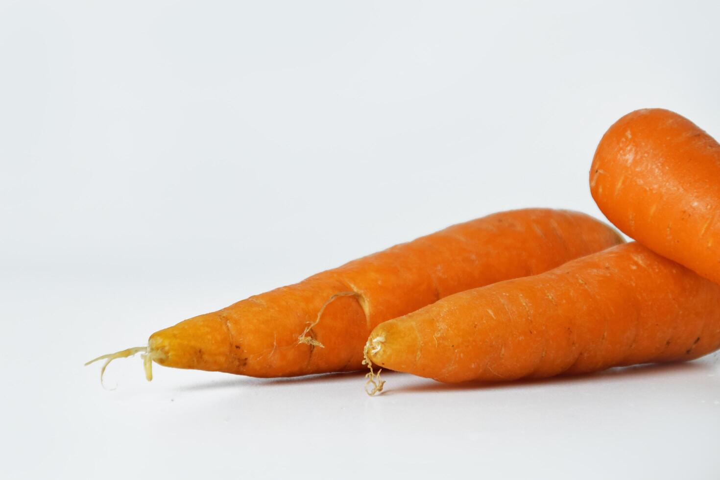 Closeup photo of orange carrots on a white background