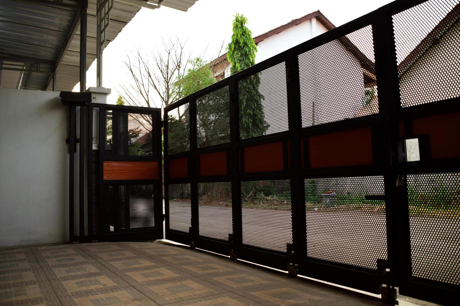 The house fence made of black iron is in the garage in front of the house photo