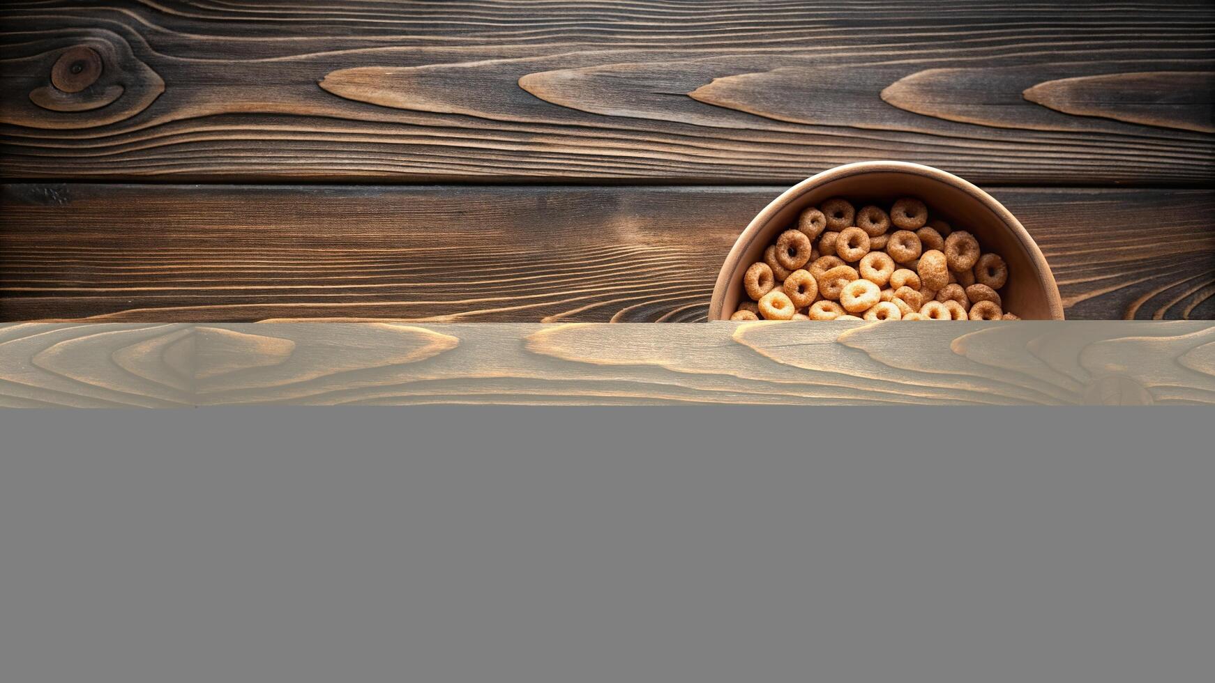 An empty ceramic bowl placed on a dark wooden table with a small amount of cereal remaining creating a symmetrical composition, ceramic,empty bowl, composition, symmetrical photo