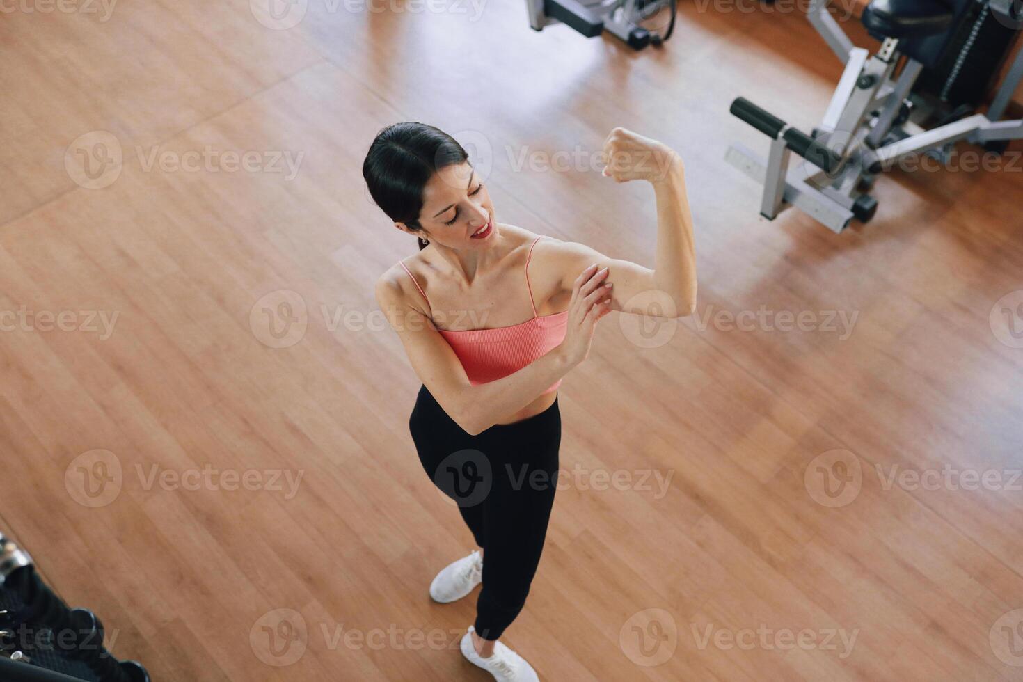 Woman Showing Her Biceps Posing In The Gym photo