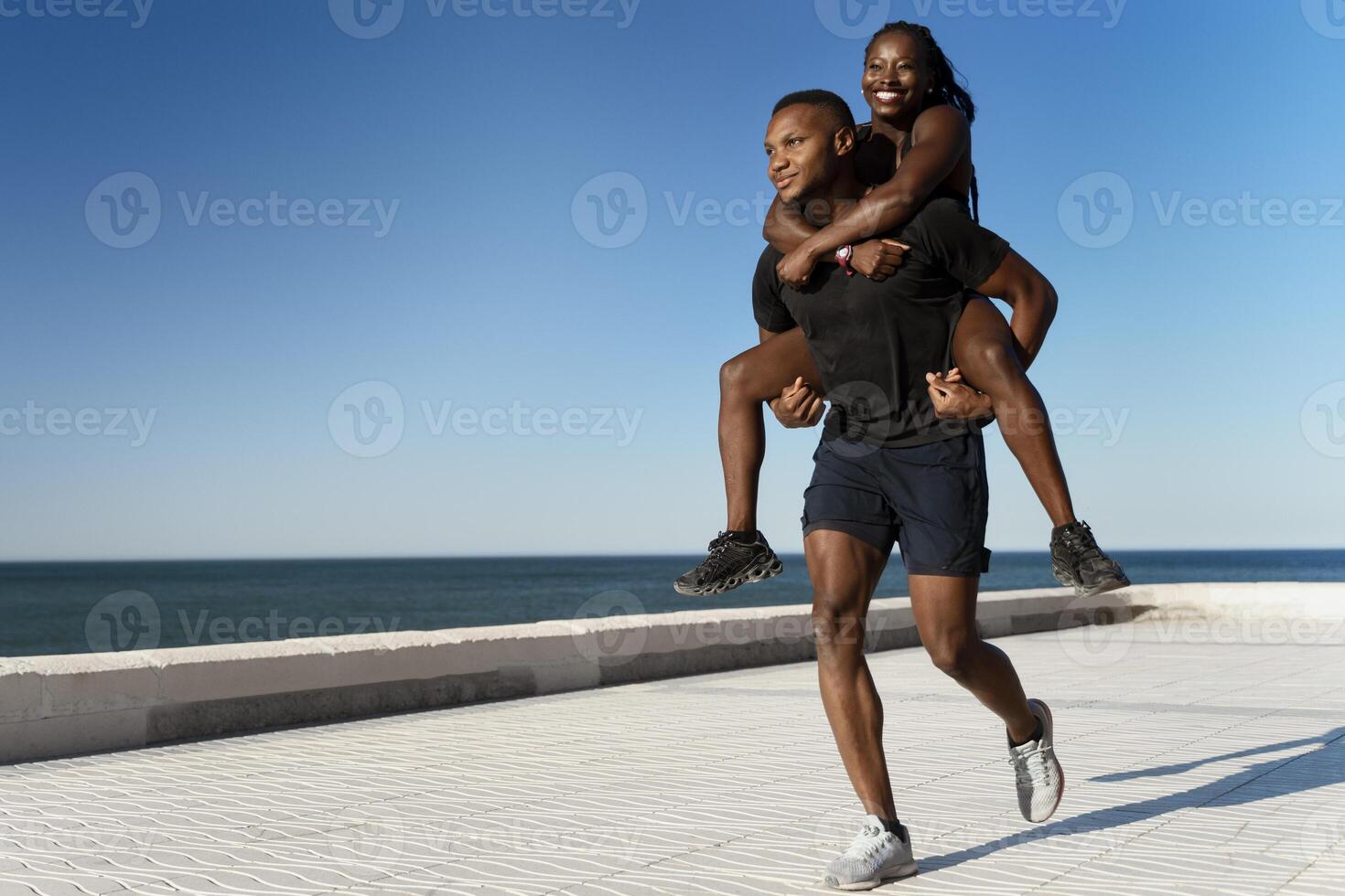 Young multiracial woman piggybacking on male boyfriend outside photo