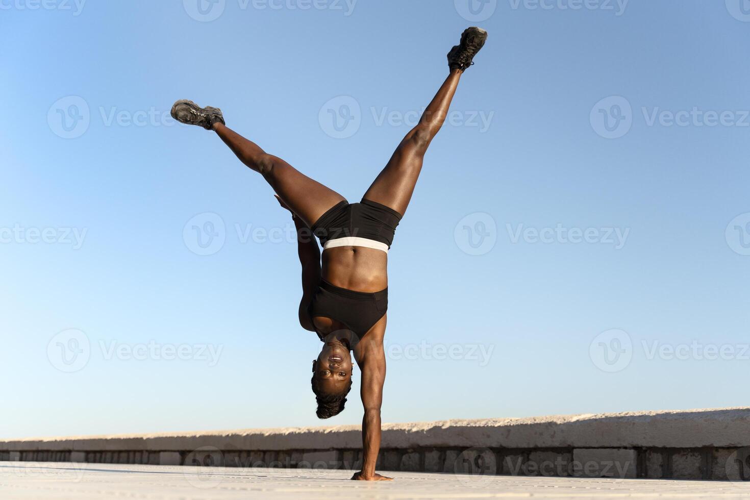 Multiracial woman at the seaside practicing yoga, training balance exercise concept lifestyle photo
