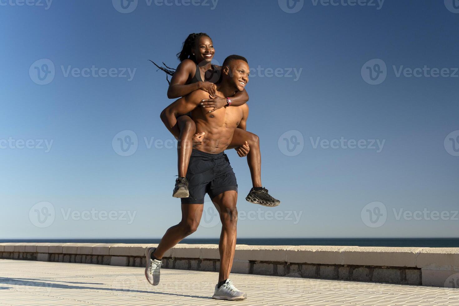 Young multiracial couple enjoying summer training near the ocean photo