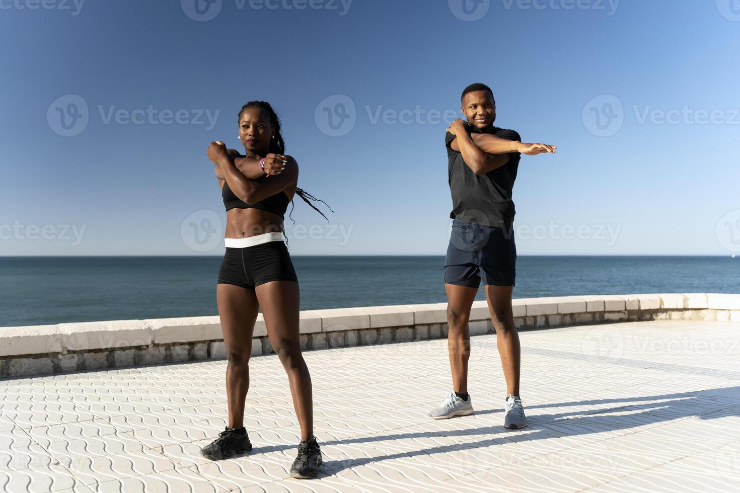 Multiracial couple sportswoman sportsman in sport clothes warming up and training photo