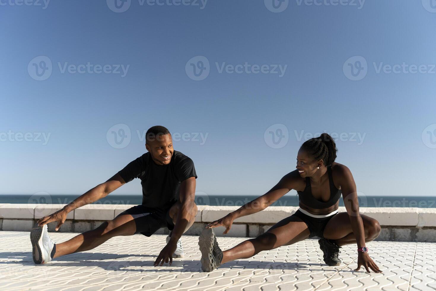 Man and woman with perfect body in sportswear warming up before intense workout outdoor photo