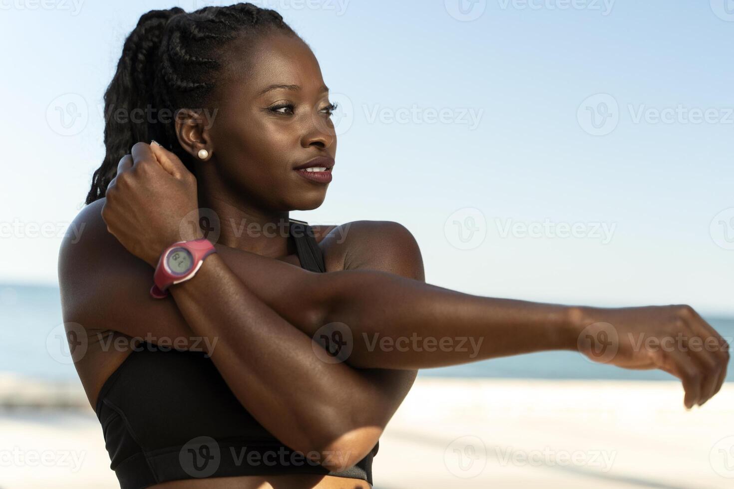 Young attractive multiracial woman in sportswear doing stretching hand before exercise photo