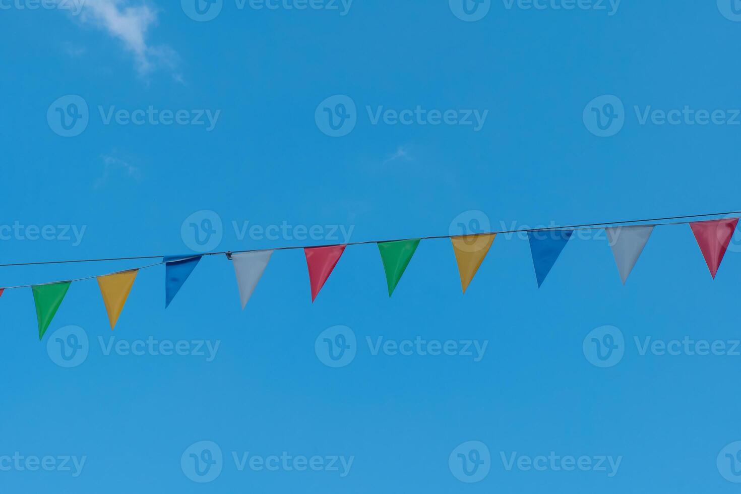 row of colorful flags are hanging from a wire photo