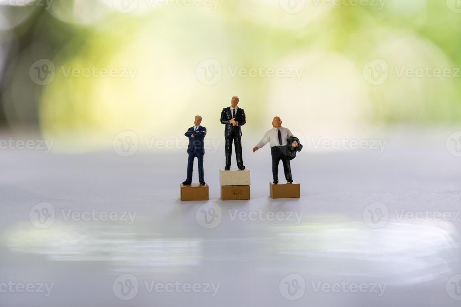 Miniature businessmen stand on white background together. Business leader, teamwork photo