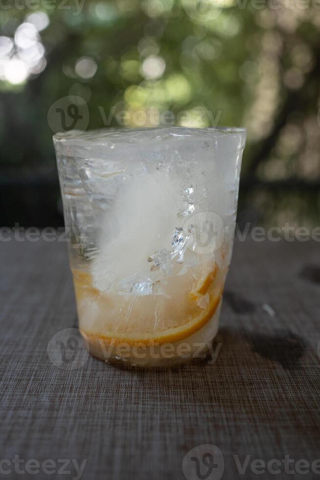 Frozen ice with slice orange fruit inside cup shape from the freezer refrigerator photo