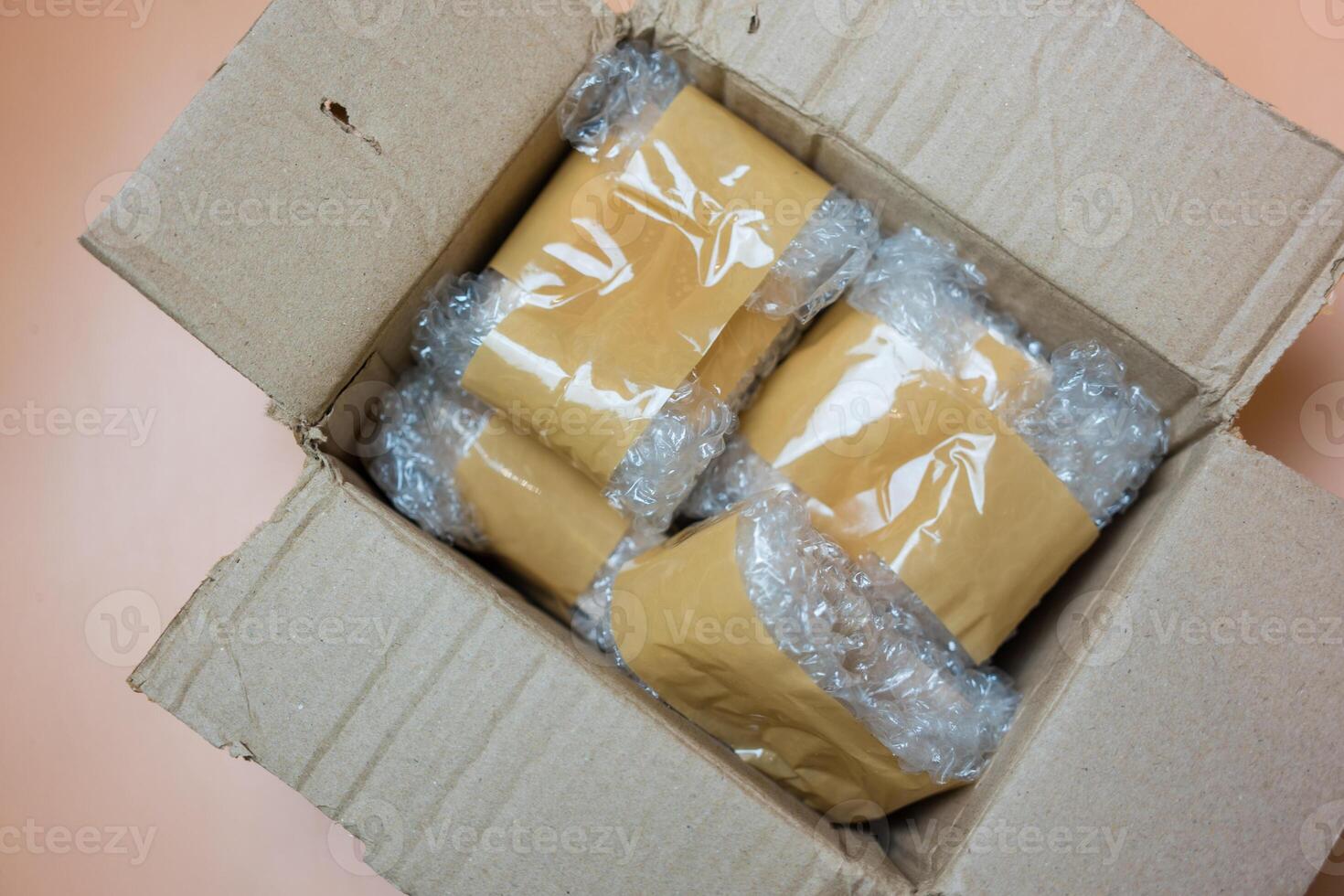 Package wrapped in white bubble wrap and adhesive tape in brown box. photo