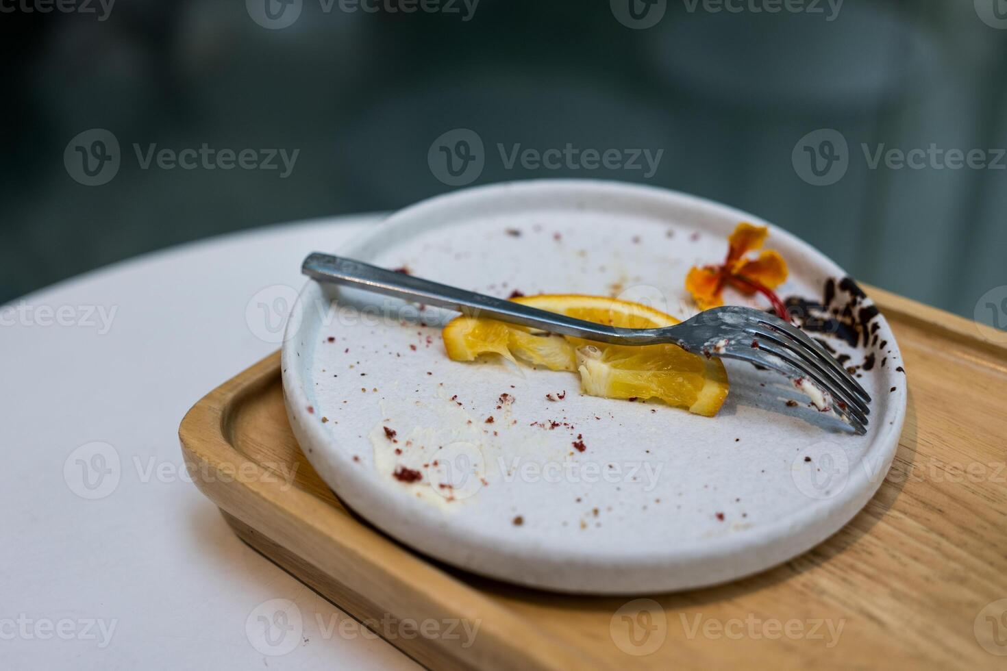 Stain of cake and piece stain of fruit after eating, dirty plate, leftover food. photo