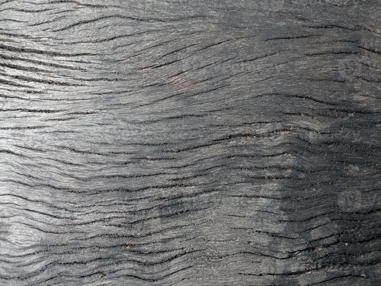 A close-up image of the surface of aged wood, revealing a rich and intricate pattern of grain and knots. photo
