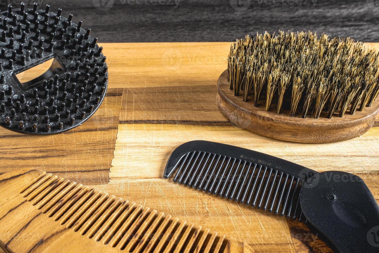 Barber shop flatlay, with different combs and brushes on a wooden table. For a beard. photo