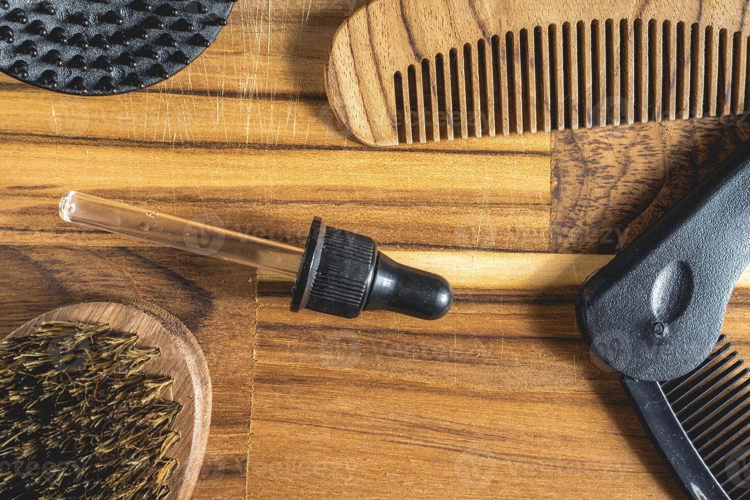 Barber shop flatlay, with different combs and brushes on a wooden table. For a beard. photo