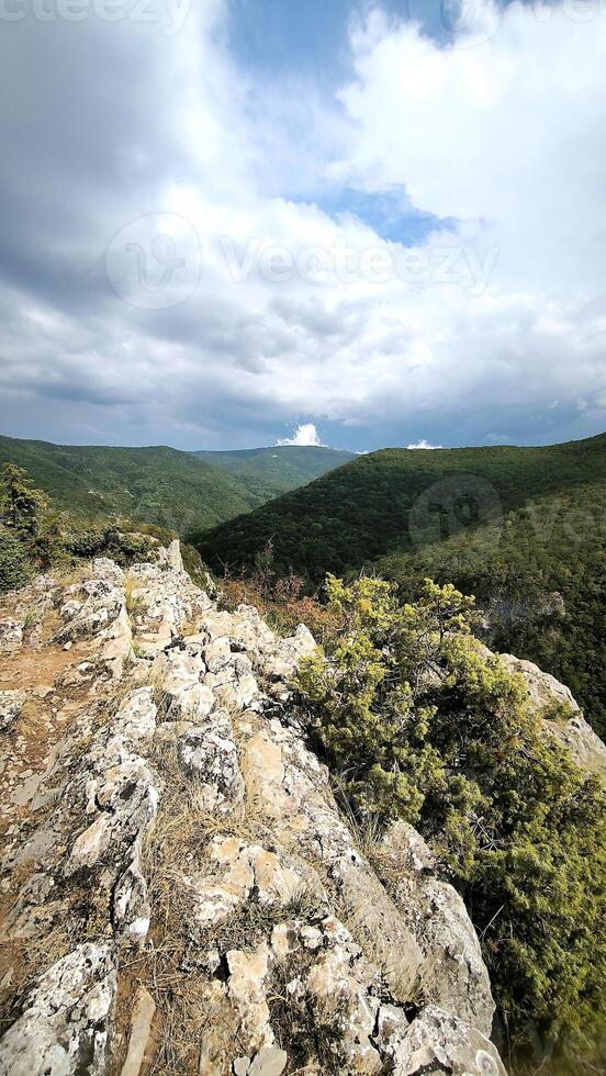 View of the high mountains with rocks on the foreground. Green mountain valley, beige stones, foggy mountains landscape, blue sky, freedom, nature, travel background, journey, meditation photo
