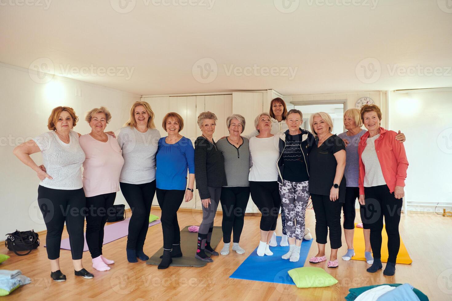 A vibrant community of senior women, guided by their instructor, embraces the enriching journey of yoga, fostering unity, well-being, and a shared commitment to active aging photo