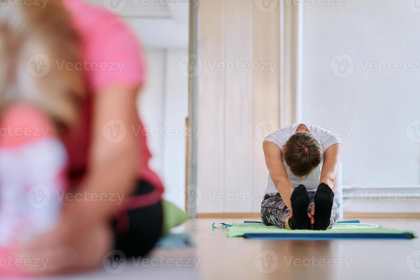 Senior Woman Practicing Back Stretches in a Sunlit Space for Optimal Health and Well Being photo