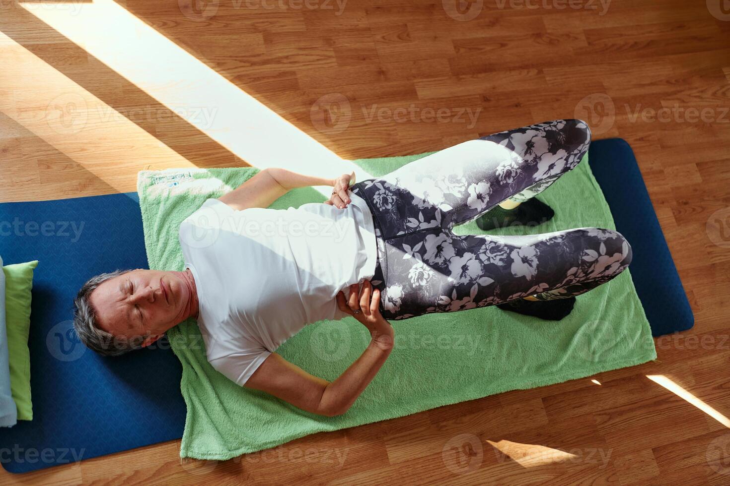 Senior woman practicing stretching and meditation on the floor, focusing on proper alignment and relaxation. photo