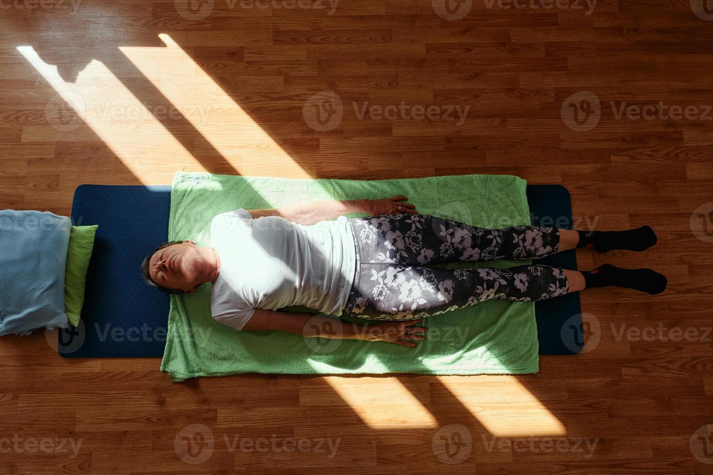 Senior woman practicing stretching and meditation on the floor, focusing on proper alignment and relaxation. photo