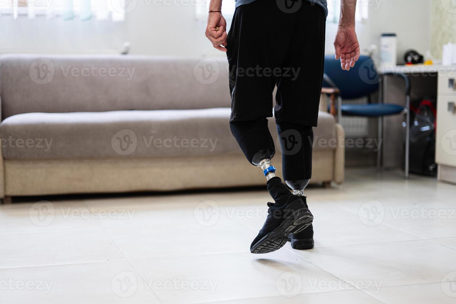 Man with prosthetic legs walking indoors in a modern setting photo