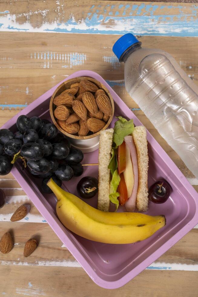 School lunch presentation. Top view showing lunch box filled with nutritious foods, protein, fruit and grains photo