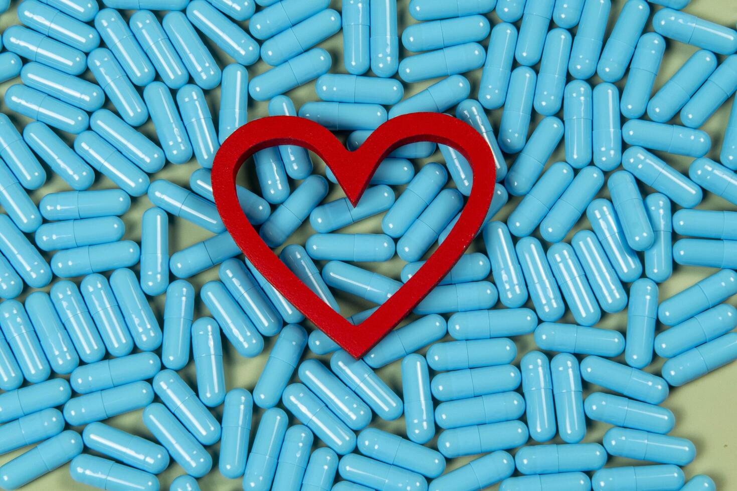 heart shape and blue capsules. Importance of medication treatment photo