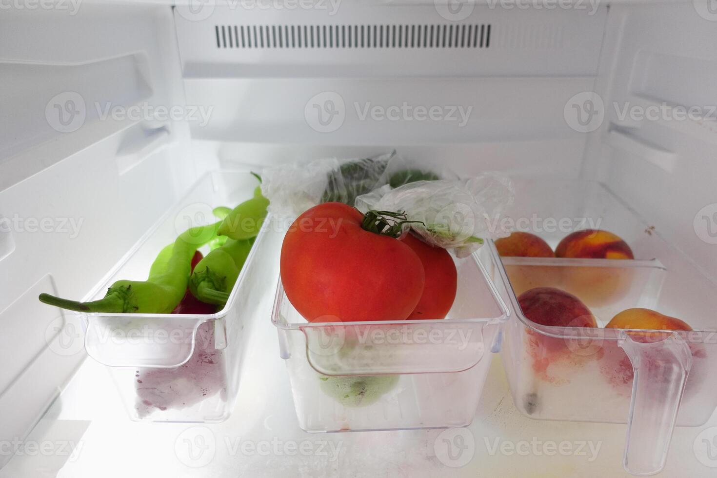 plastic containers with different fruits in a open fridge. photo