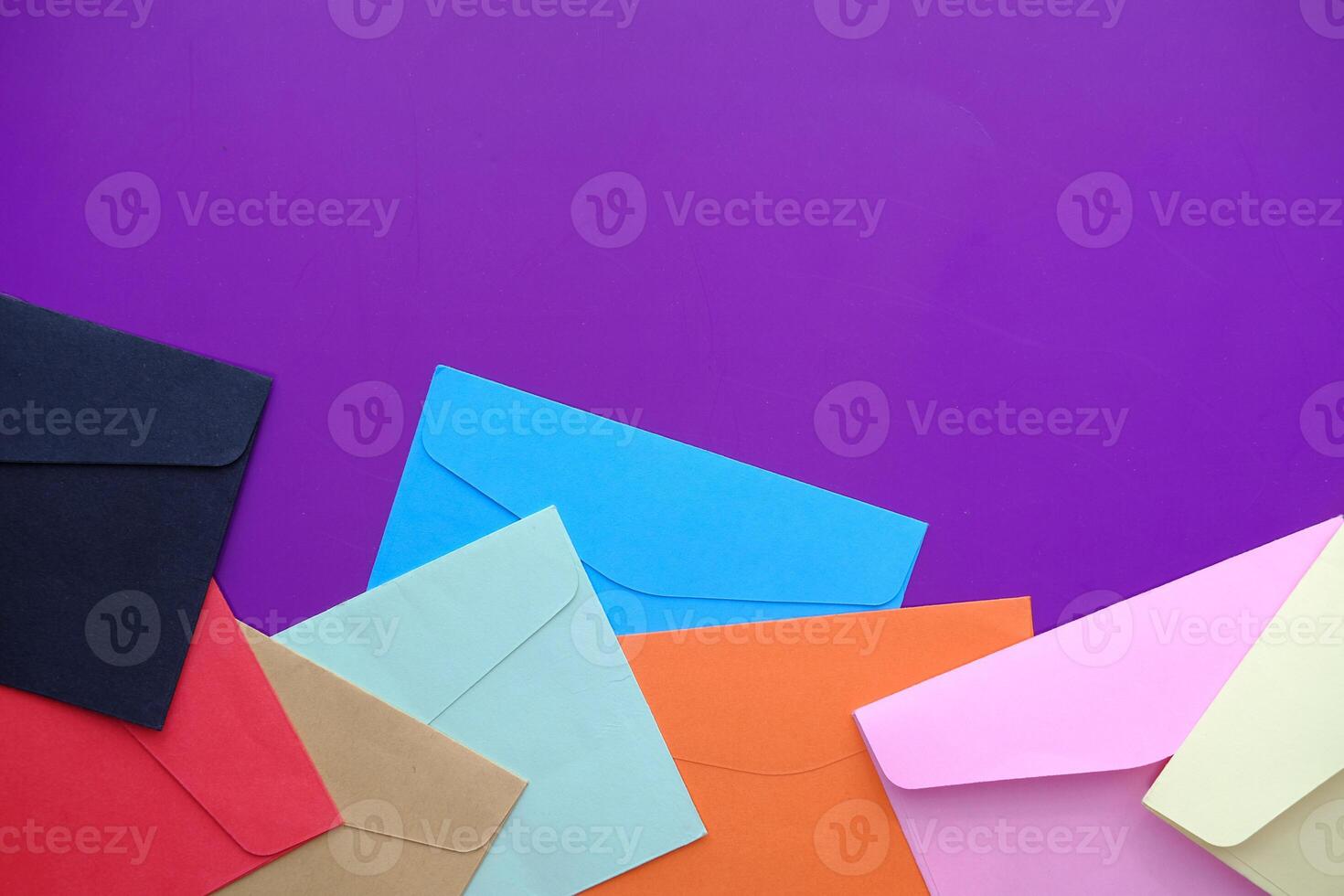 Vibrantly Colorful Envelopes on a Purple Background Perfect for Creative Projects and More photo