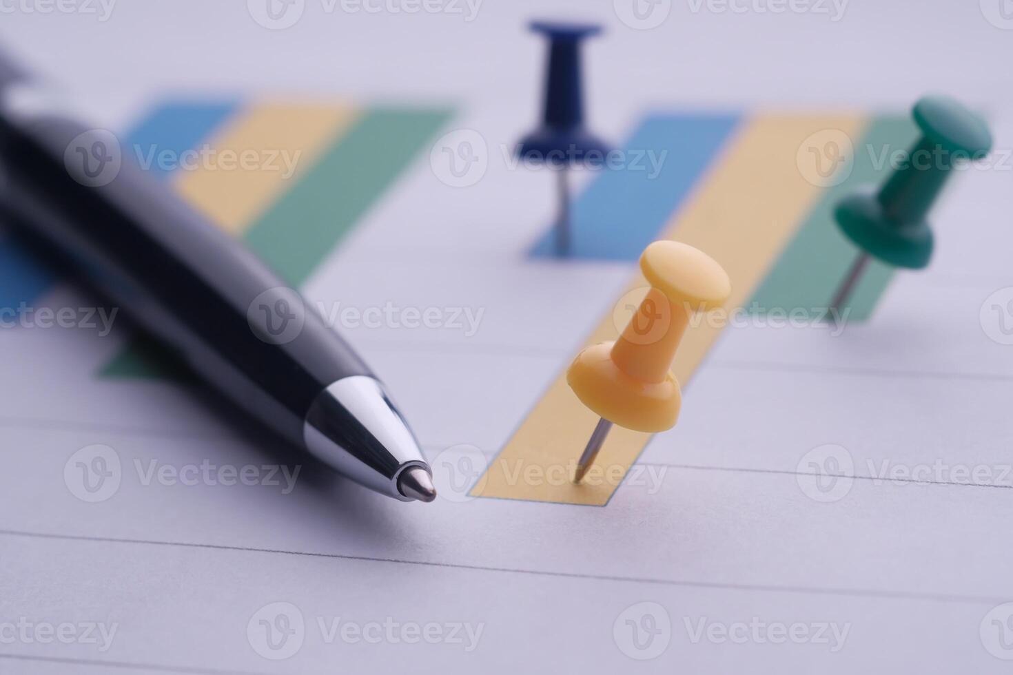 Vibrantly Colored Push Pins on a Planner Accompanied by a Sleek Black Pen for Reference photo