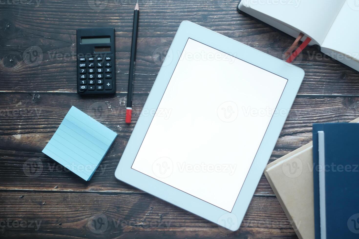 Minimalistic Workspace with Tablet, Calculator, and Notepad on Rustic Wooden Table photo