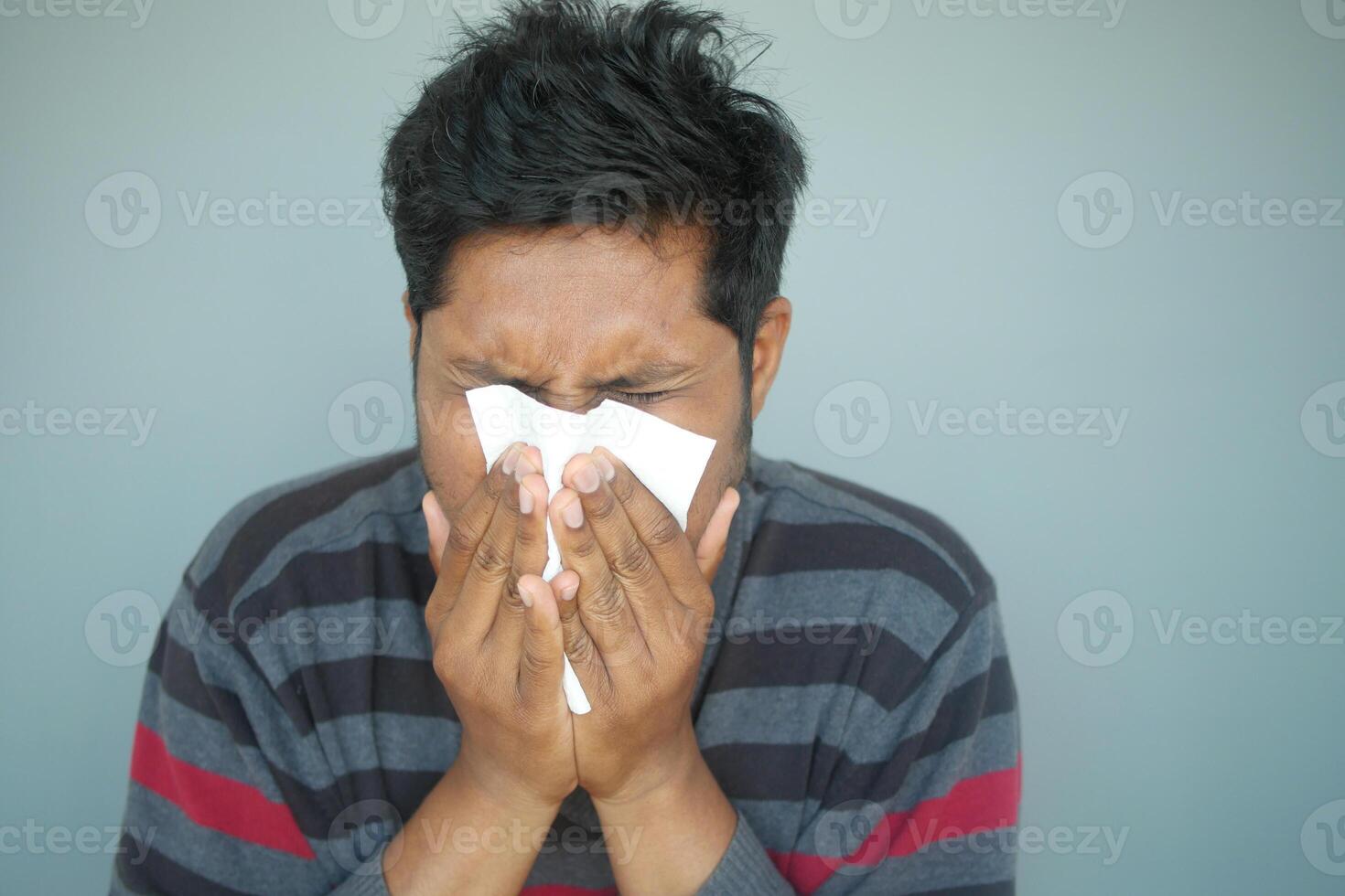 Sick man with flu blow nose with napkin. photo