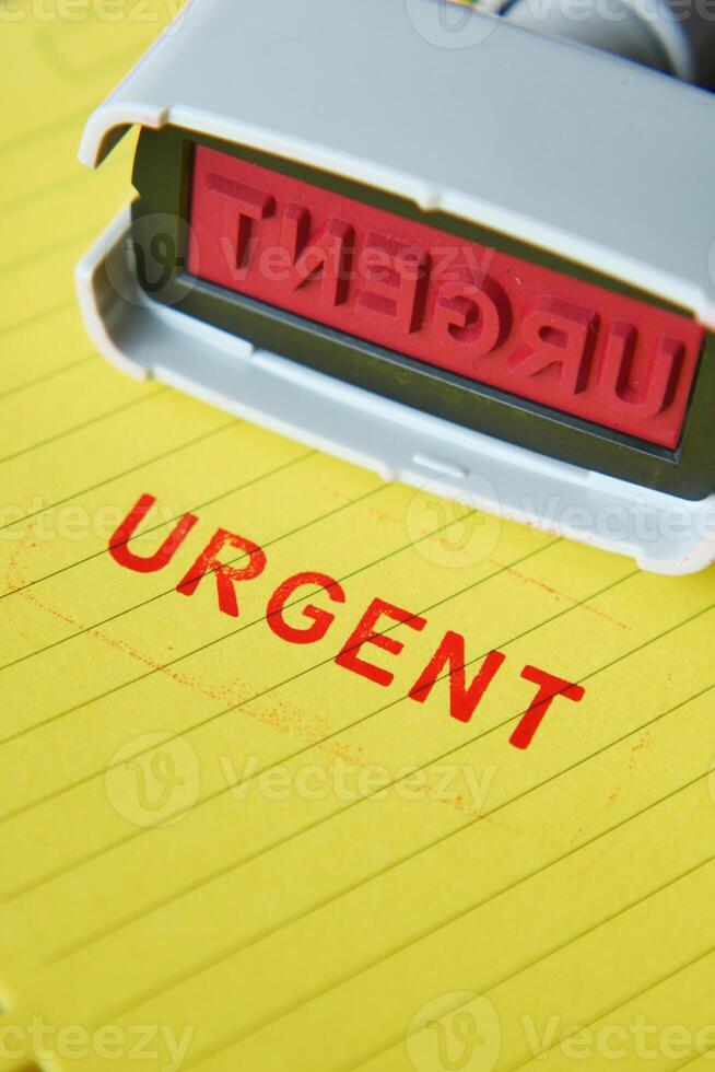 Red URGENT word stamp on a white paper photo