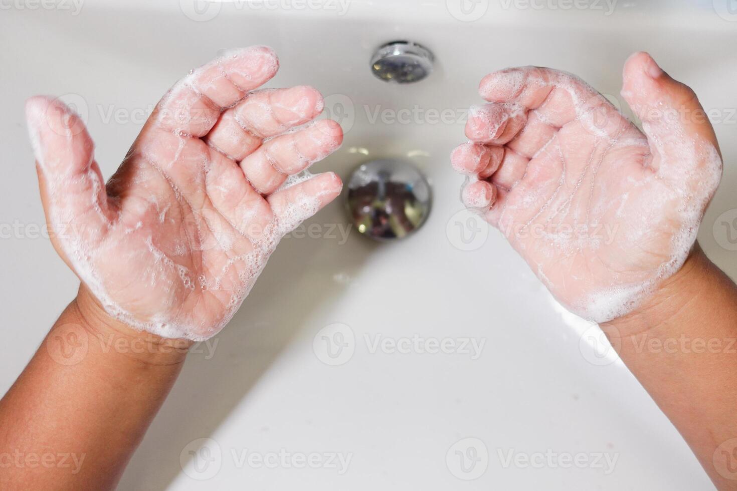 Child Washing Hands with Soap Under Running Faucet Essential Hygiene Practice for Health photo