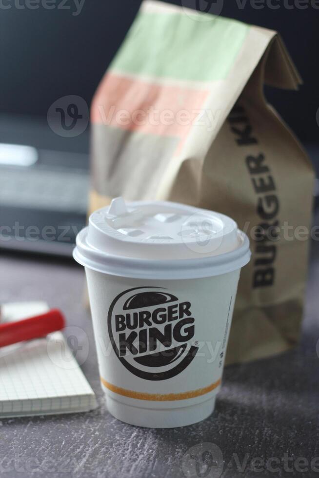 WASHINGTON - USA - August 17, 2024 - A Burger King coffee cup sits on a desk, next to a notebook and pen. photo