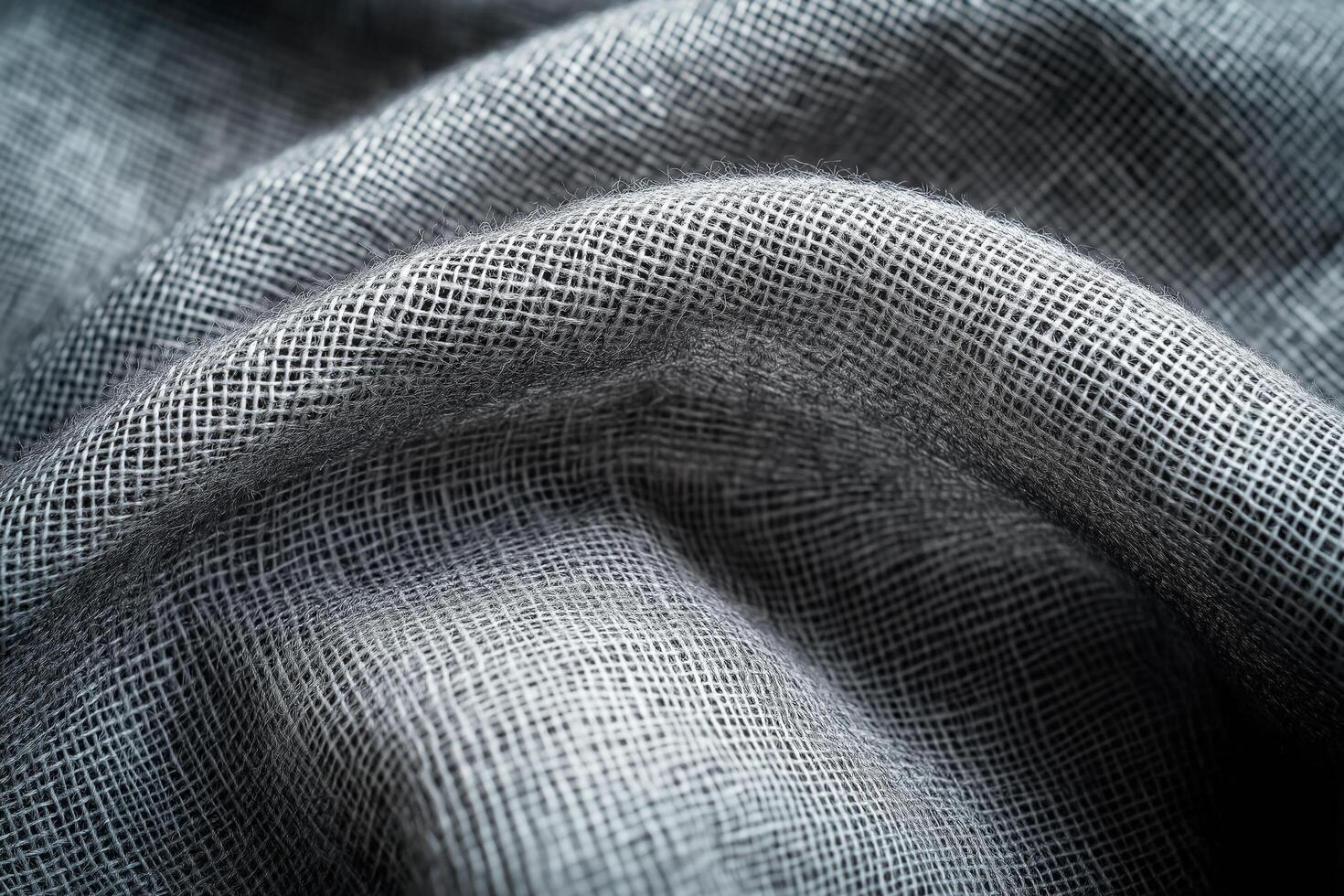 Dark, textured fabric with a rough, woven pattern, creating a rich and tactile surface with deep folds photo