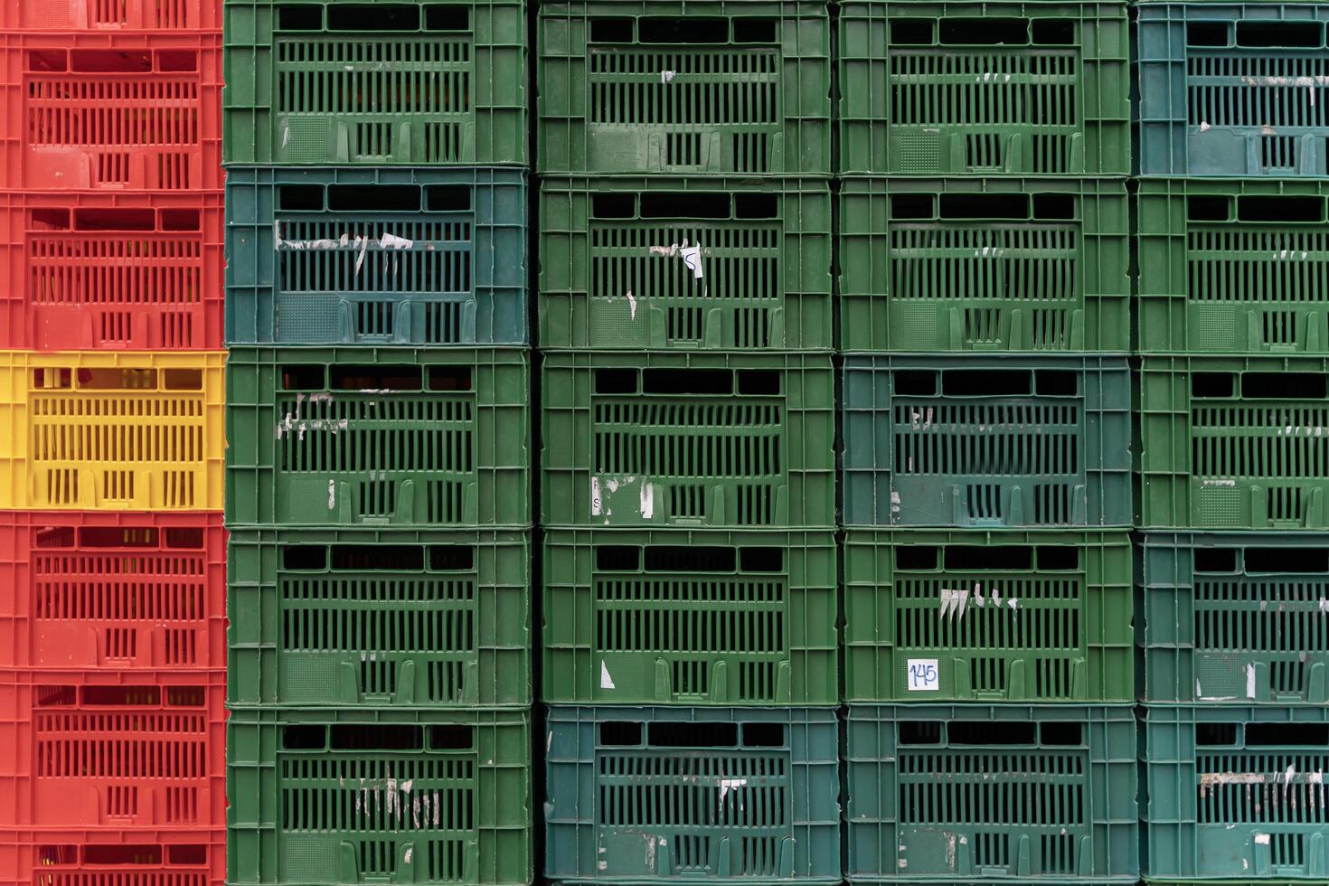 Close up to plastic baskets colorful baskets wall background. Colorful plastic boxes stacked one upon the other. photo